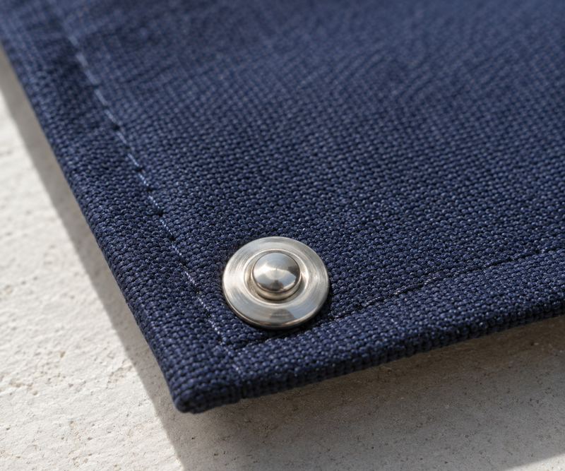 Close-up of navy Sunbrella acrylic canvas weave with a stainless snap
