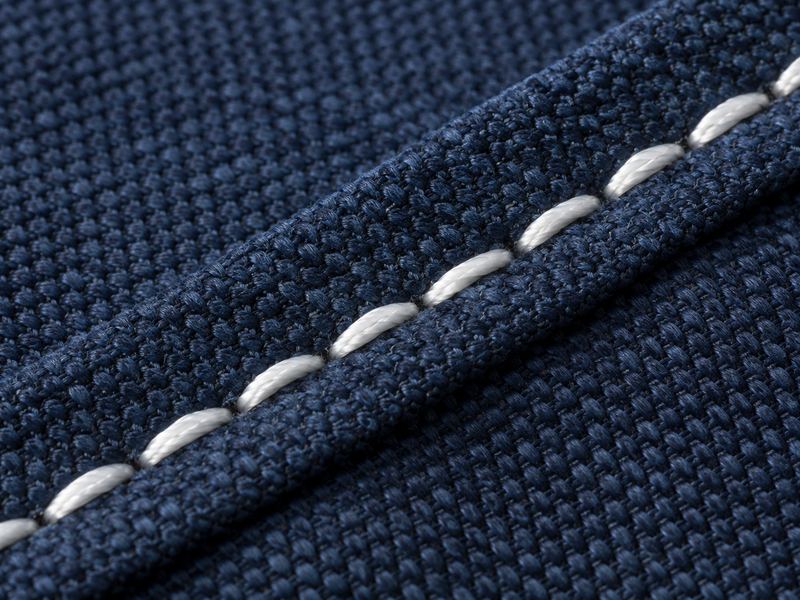 Close-up of a white PTFE thread seam on navy canvas