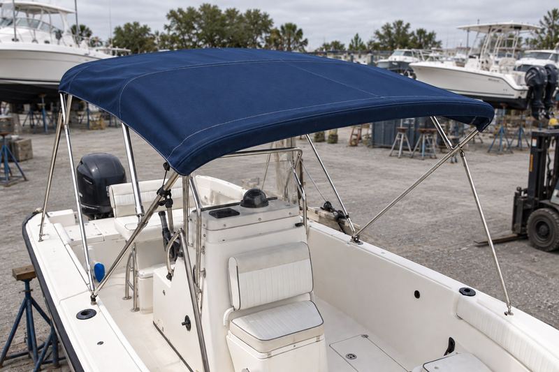 The same boat with a taut new navy Sunbrella bimini on a polished stainless frame