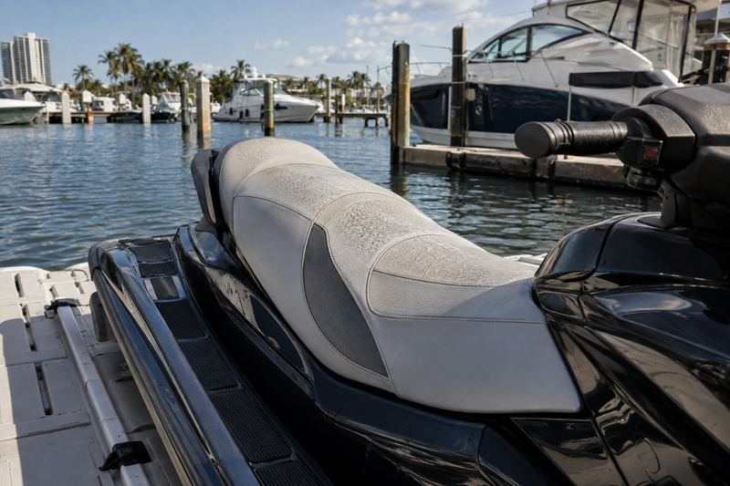 Jet ski seat with cracked, faded black and purple vinyl and split seams