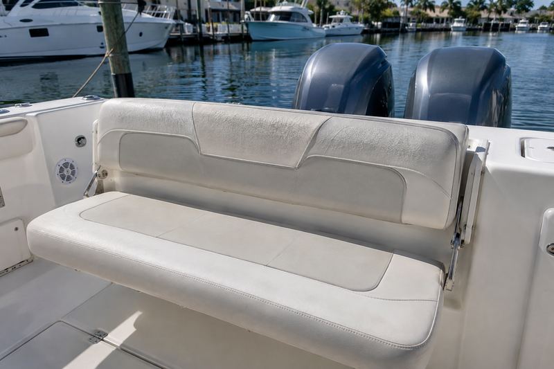 Aft bench seat of a 28 ft center console in faded tan vinyl with teal and burgundy stripes