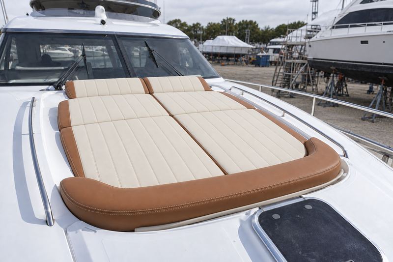 Motor yacht foredeck, sunpad in cream with a cognac bolster