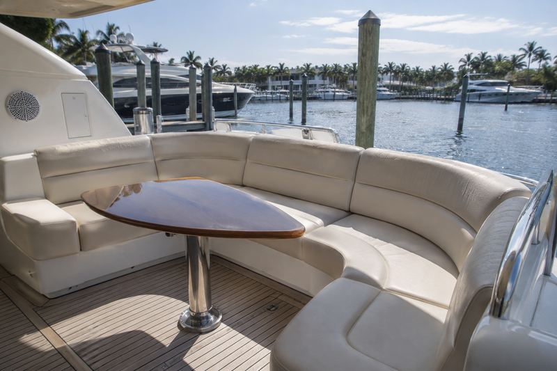 Aft deck settee of a 65 ft motor yacht in faded beige vinyl with brown piping